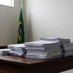 Documentos eleitorais e bandeira no TRE-RO sobre cassações por fraude à cota de gênero