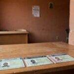 Prédio público em Vilhena com documentos RG, CPF e CNH sobre mesa de atendimento
