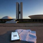 Smartphone com Pix e documentos de pensão alimentícia em frente ao Congresso Nacional