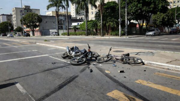 Acidente entre moto e bicicleta na Avenida Melvin Jones com veículos danificados