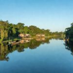 Vista do Rio Madeira em Porto Velho com vegetação amazônica e casas ribeirinhas
