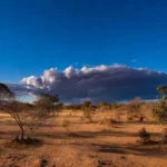 Paisagem de Vilhena com sol forte e nuvens de tempestade representando previsão de calor e chuvas.