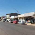 Avenida Integração Nacional em Cerejeiras com comércios e veículos